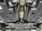 The underside of a Toyota Prius with a catalytic converter in the middle
