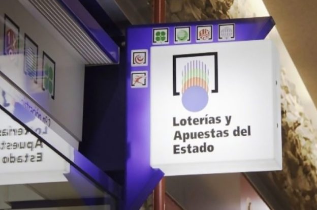 A sign for lottery products hangs outside a shop in Spain