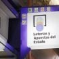 A sign for lottery products hangs outside a shop in Spain