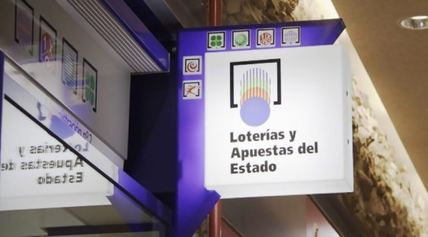 A sign for lottery products hangs outside a shop in Spain