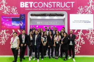 BetConstruct employees pose in front of a company booth at G2E