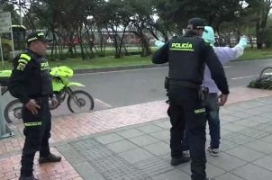 Colombian police search a suspect on the streets