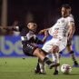 Brazilian soccer players battle for the ball on the field