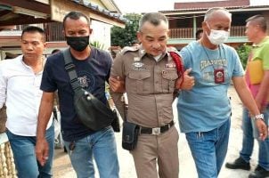 Plainsclothes police officers escort Wuttisak Phittakchan-im (center) to jail