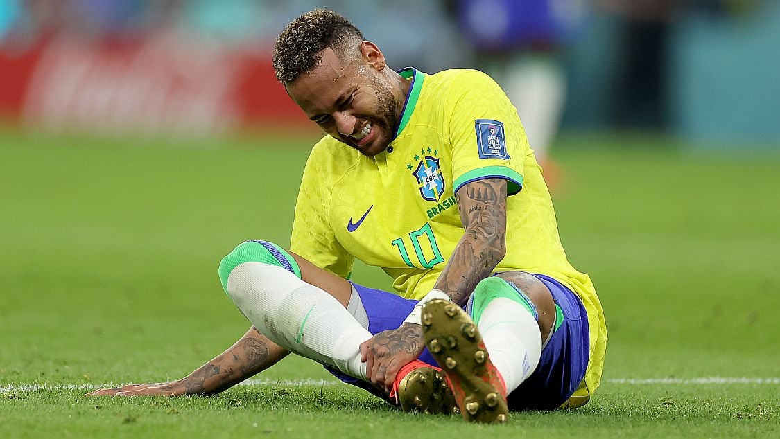 Futbol yıldızı Neymar, maç sırasında sakatlandıktan sonra ayak bileğini tutuyor.