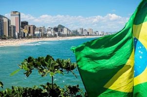 The Brazilian flag flies in front of a beach