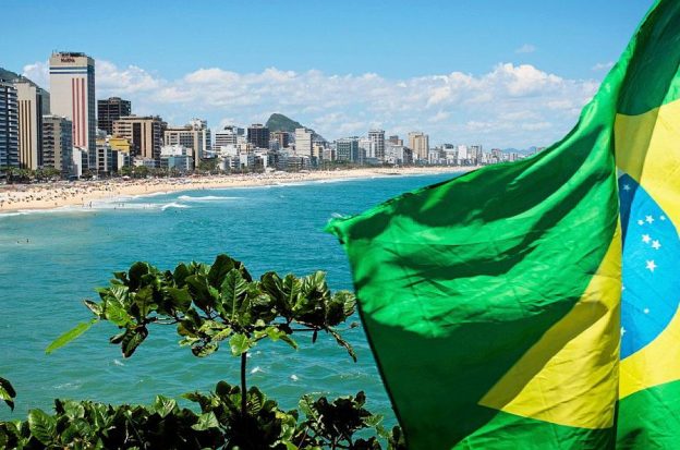 The Brazilian flag flies in front of a beach