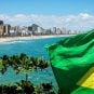 The Brazilian flag flies in front of a beach