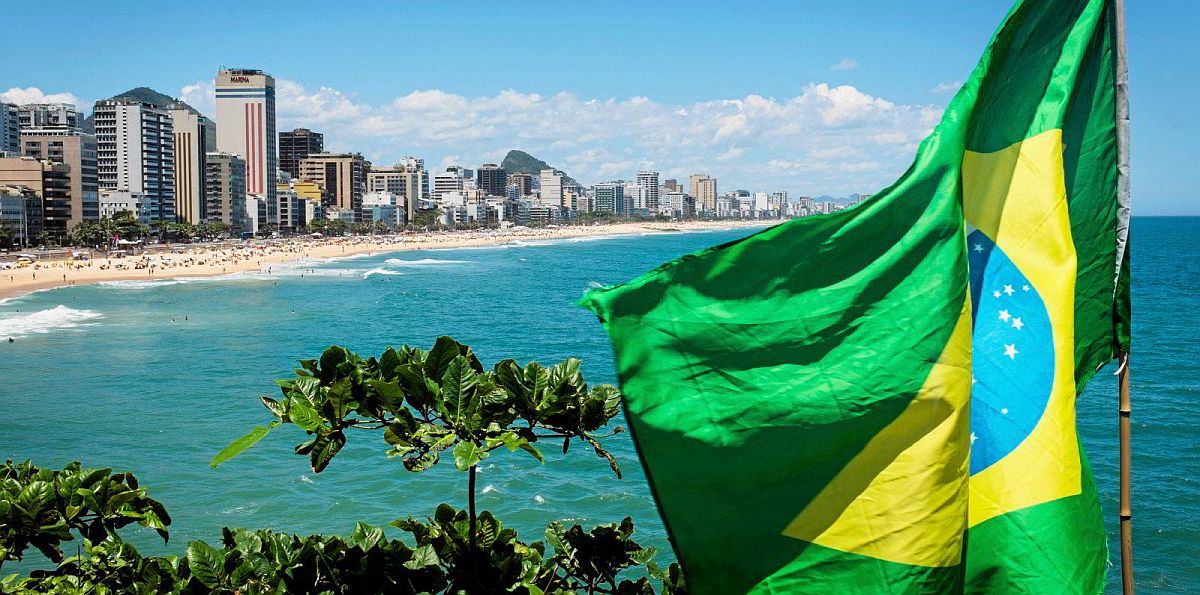 The Brazilian flag flies in front of a beach