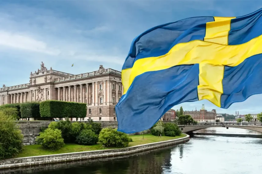 The Swedish flag, with Stockholm Palace in the background