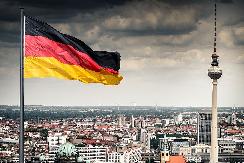 Germany's flag flies in front of the Fernsehturm in central Berlin