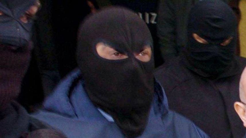 Hooded figures belonging to the 'Ndrangheta mafia are led away by Italian police