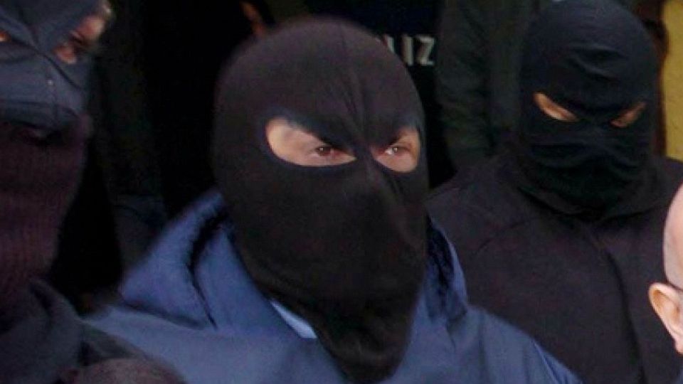 Hooded figures belonging to the 'Ndrangheta mafia are led away by Italian police