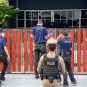 Police officers prepare to arrest Pakpoom Saengnil in Thailand