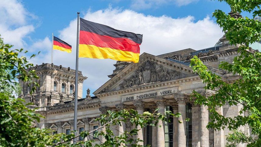 Bendera persatuan Jerman berkibar dengan warna nasional di depan gedung Reichstag