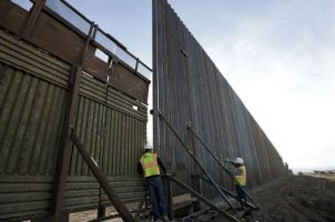 Workers install a section of the border wall between the US and Mexico