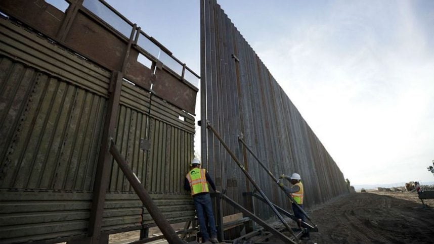 Workers install a section of the border wall between the US and Mexico