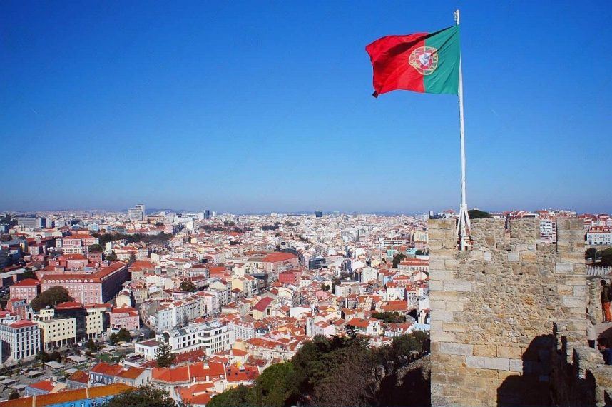 The Portuguese flag flies from a castle overlooking the city of Lisbon
