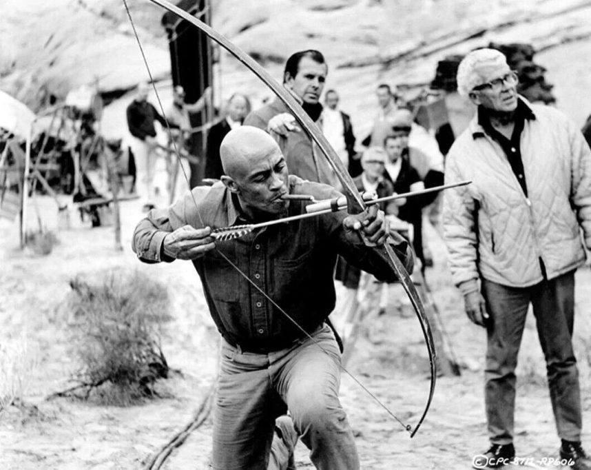 Woody Strode takes aim during a rehearsal for the film The Professionals"