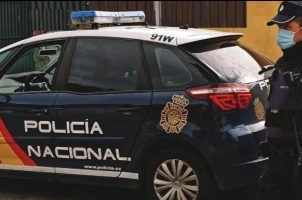 A police officer in Spain stands next to his vehicle