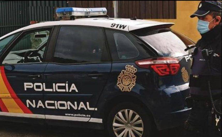 A police officer in Spain stands next to his vehicle