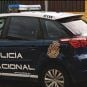 A police officer in Spain stands next to his vehicle