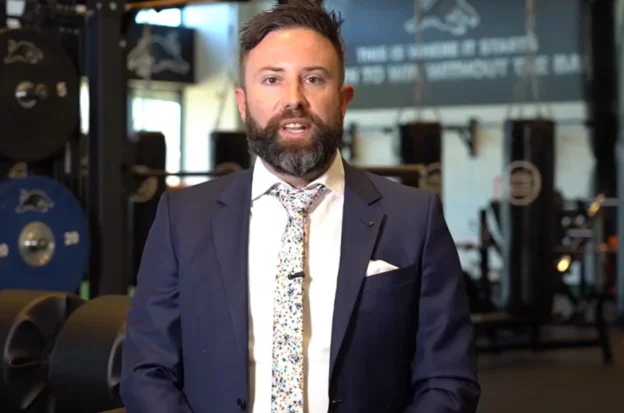 Australian accountant Ben Carter wearing a suit in a gym