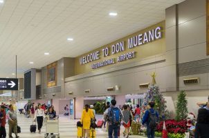 Travelers walk through the Don Mueang International Airport in Bangkok, Thailand