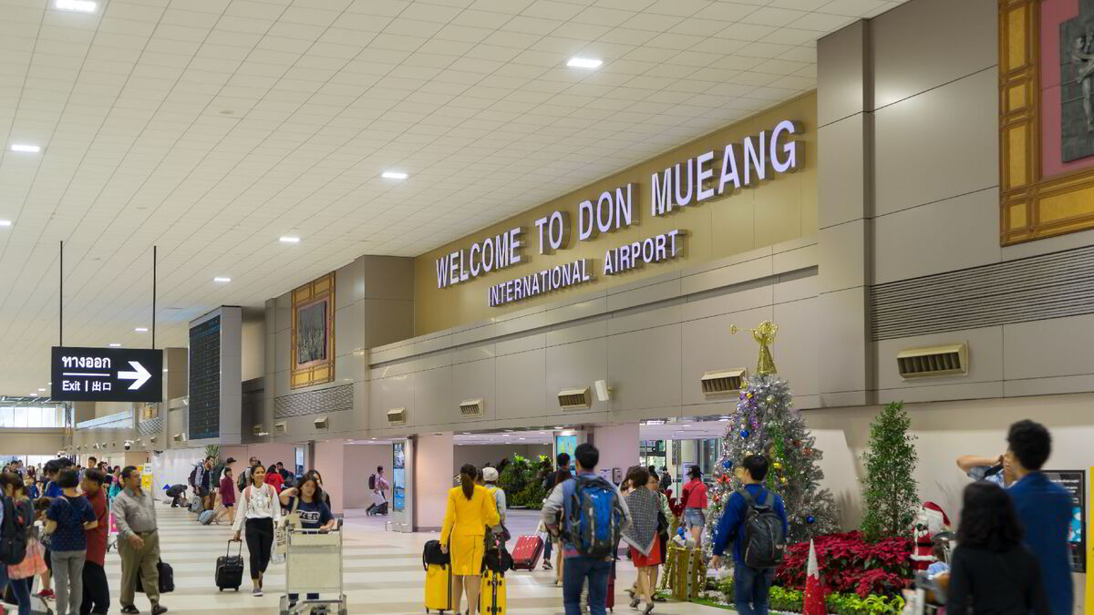 Travelers walk through the Don Mueang International Airport in Bangkok, Thailand