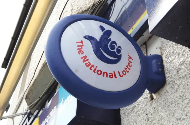 A UK National Lottery sign hangs over a vendor's store