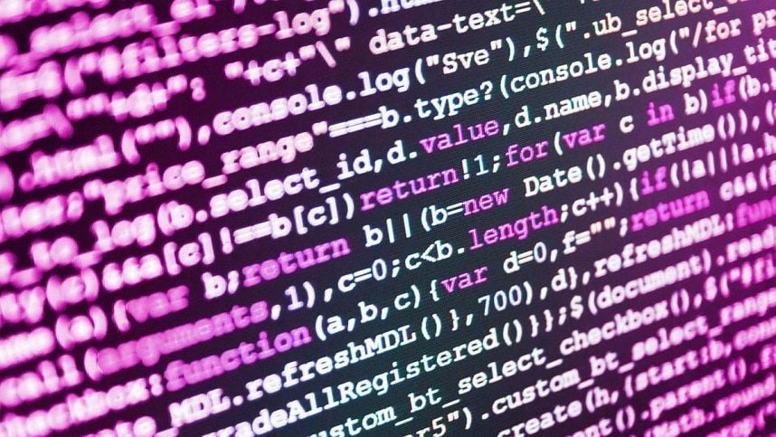 A computer monitor displays programming code