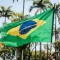 A man holds a tattered Brazilian flag