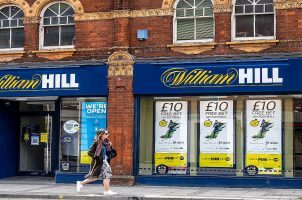 A person walks by a William Hill shop
