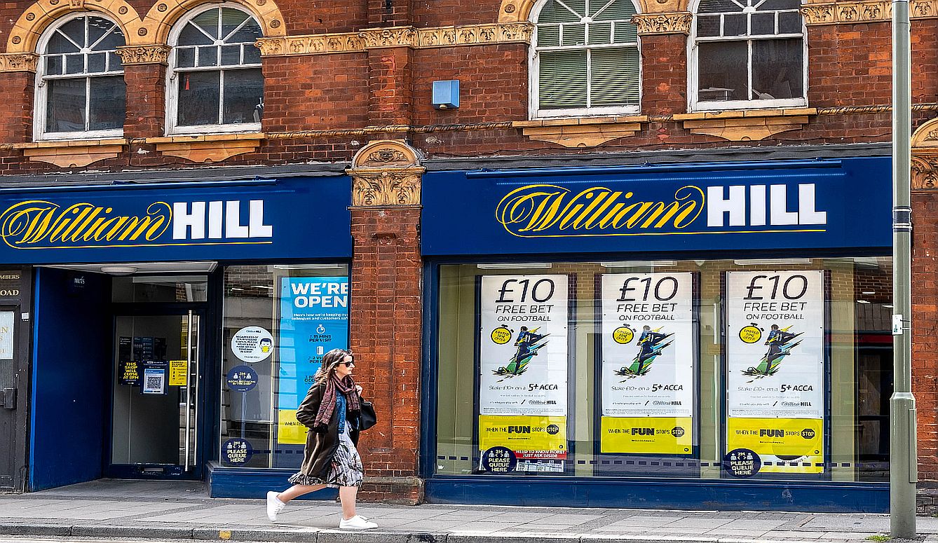 A person walks by a William Hill shop