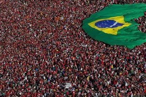Brazilians gather and display a Brazilian flag during the presidential inauguration ceremony in Brasilia on New Year's Day 2023