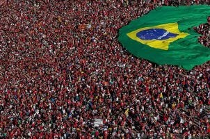 Brazilians gather and display a Brazilian flag during the presidential inauguration ceremony in Brasilia on New Year's Day 2023