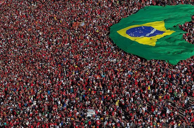 Brazilians gather and display a Brazilian flag during the presidential inauguration ceremony in Brasilia on New Year's Day 2023