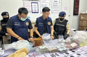 Thai police officers inventory goods seized during a raid of an illegal gambling hall