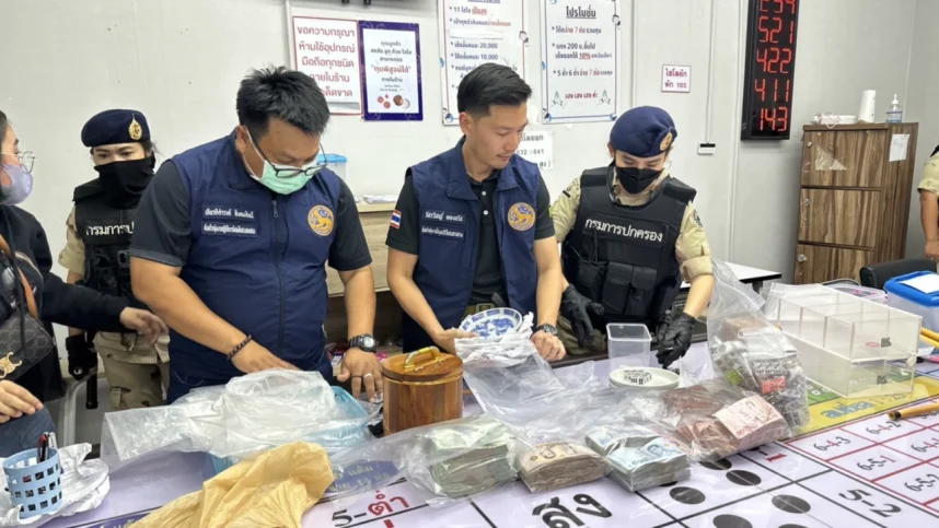 Thai police officers inventory goods seized during a raid of an illegal gambling hall