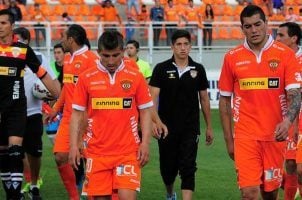 The players of Chile's Cobreloa club head to the locker room with their heads down after a game