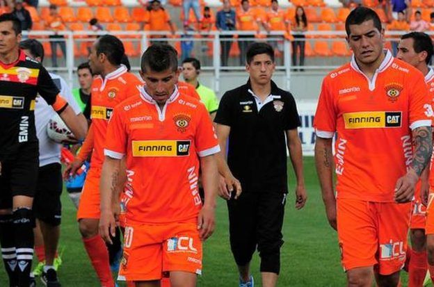 The players of Chile's Cobreloa club head to the locker room with their heads down after a game