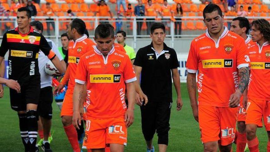 The players of Chile's Cobreloa club head to the locker room with their heads down after a game