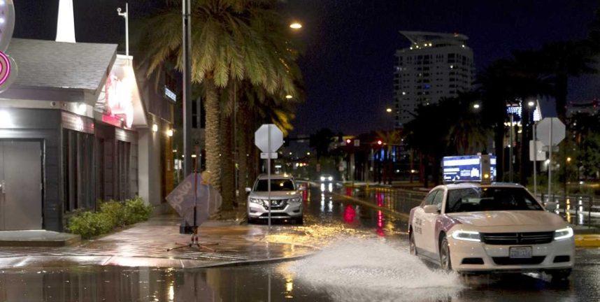 A taxi drives through flooded roads