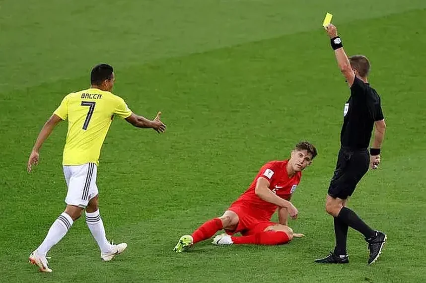 A soccer player receives a yellow card from a referee during a match