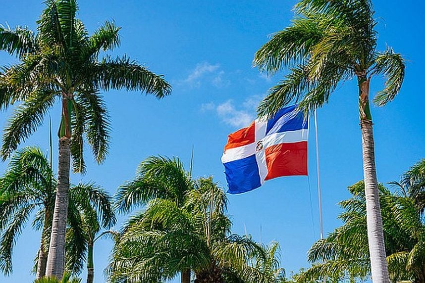 The flag of the Dominican Republic flying amid palm trees