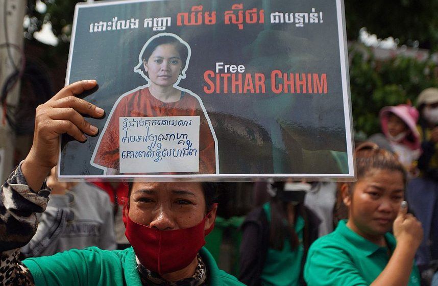 A NagaWorld worker holds a sign protesting the arrest of Chhim Sithar