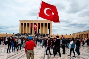 A man holds the national flag of Turkey in front of the mausoleum of Mustafa Kemal Ataturk, the founder of modern Turkey