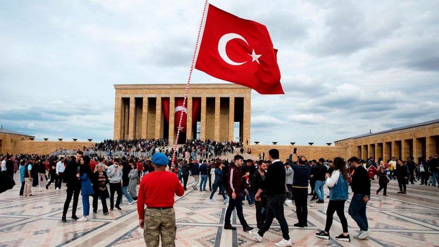 A man holds the national flag of Turkey in front of the mausoleum of Mustafa Kemal Ataturk, the founder of modern Turkey
