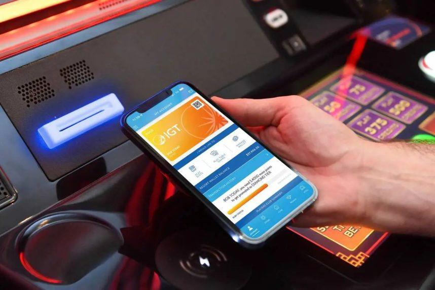 A player prepares to use a cashless gaming app on a gaming machine