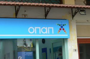 A sign displays the OPAP logo on a betting shop in Greece